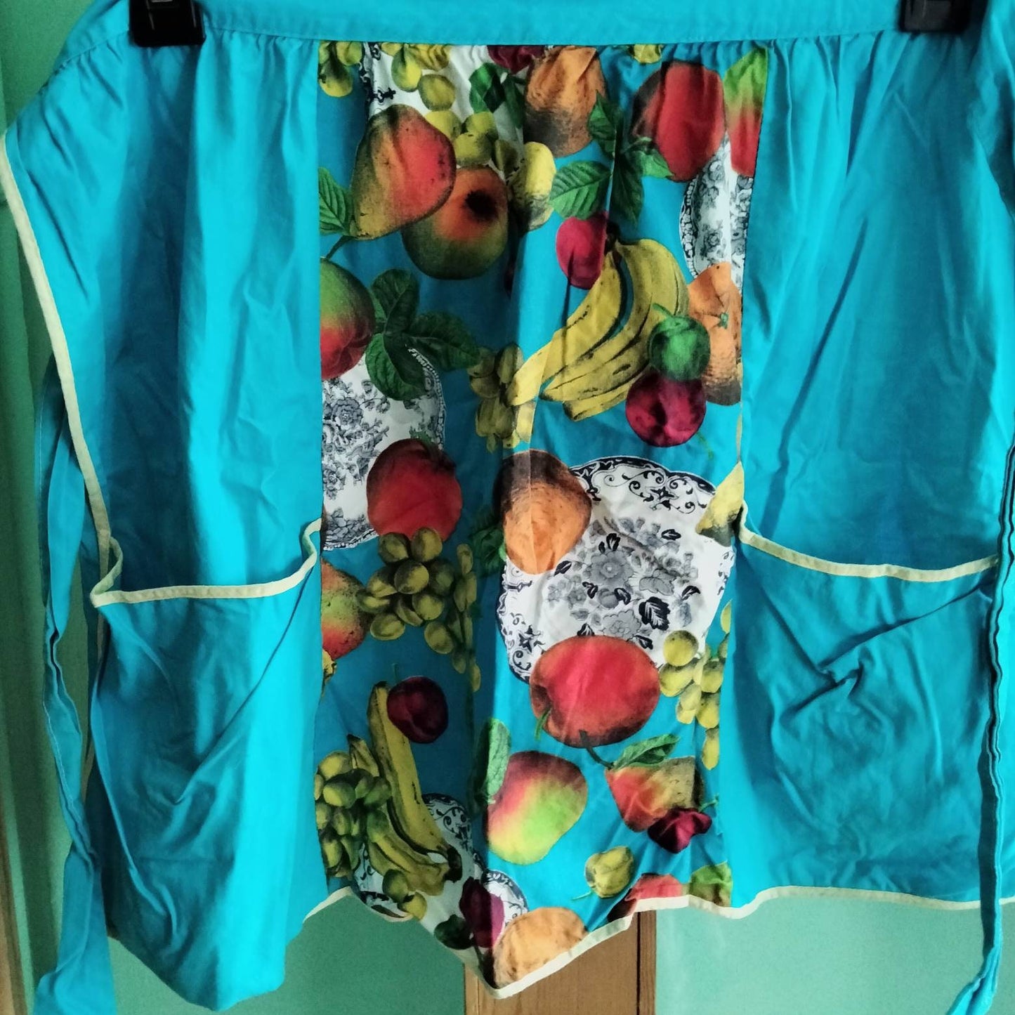 C1970s Conquest turquoise blue and fruit & plate print apron