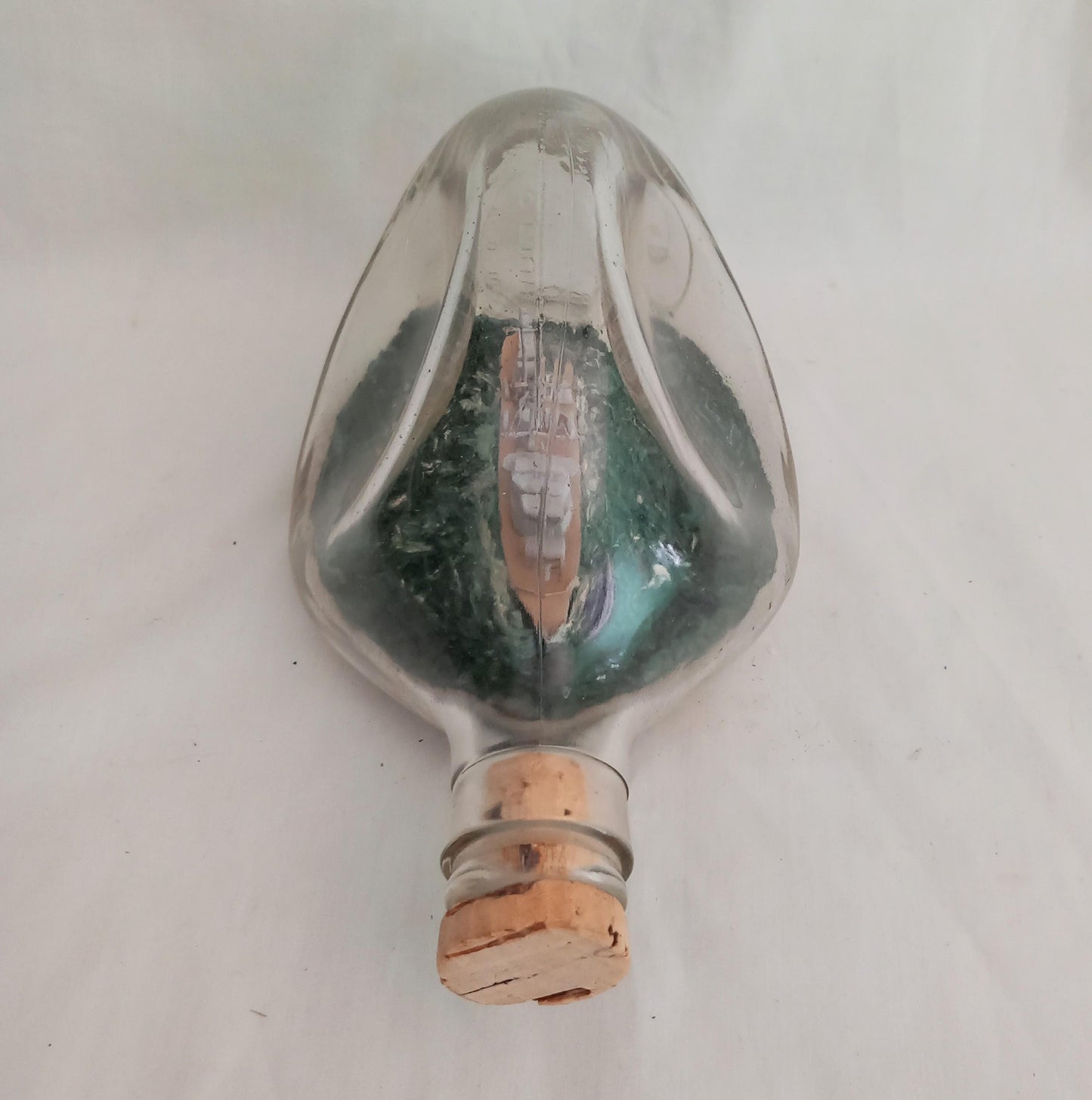 vintage hand made ship in a bottle of HMS Ajax in pinched triangular bottle