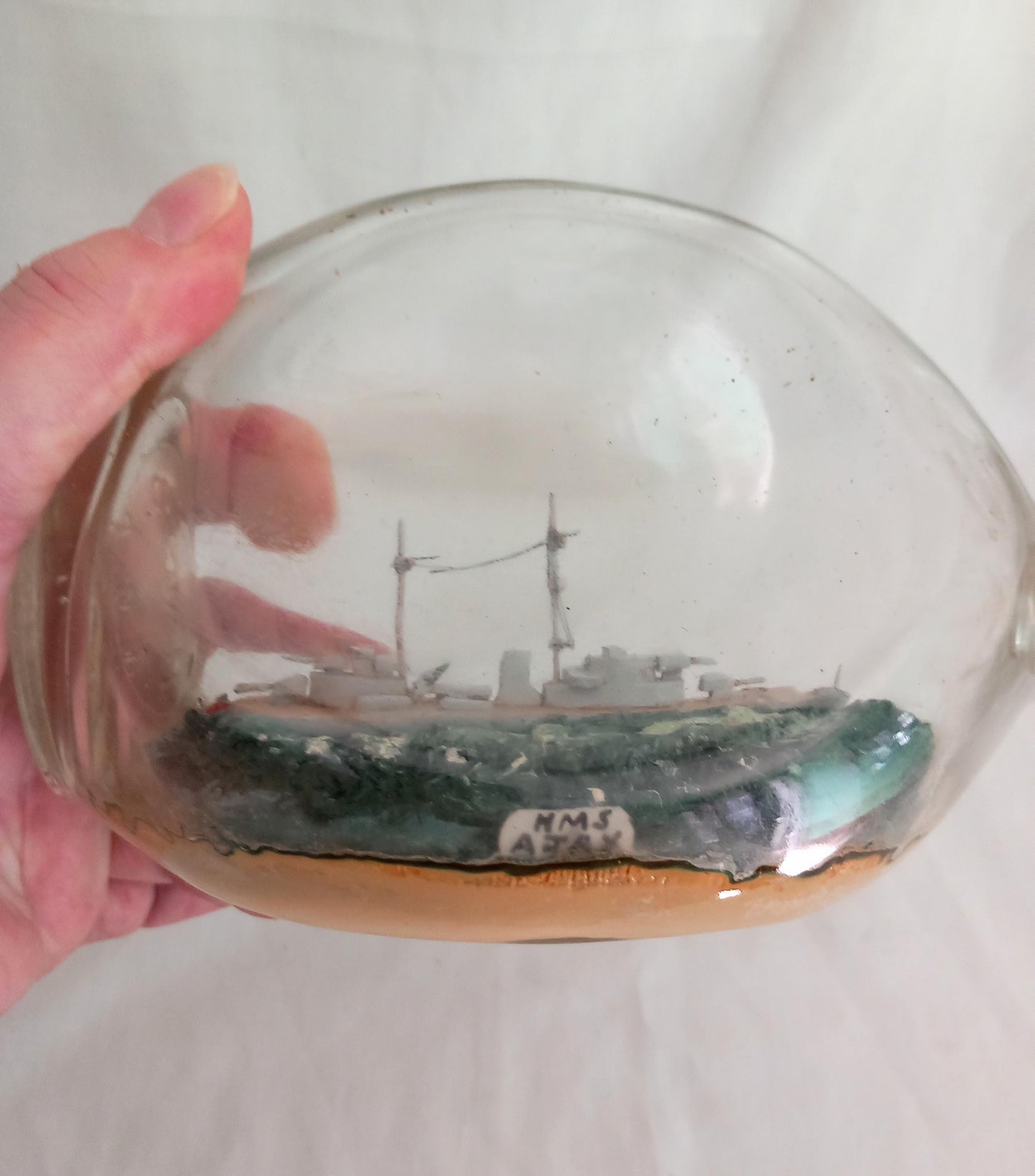 vintage hand made ship in a bottle of HMS Ajax in pinched triangular bottle