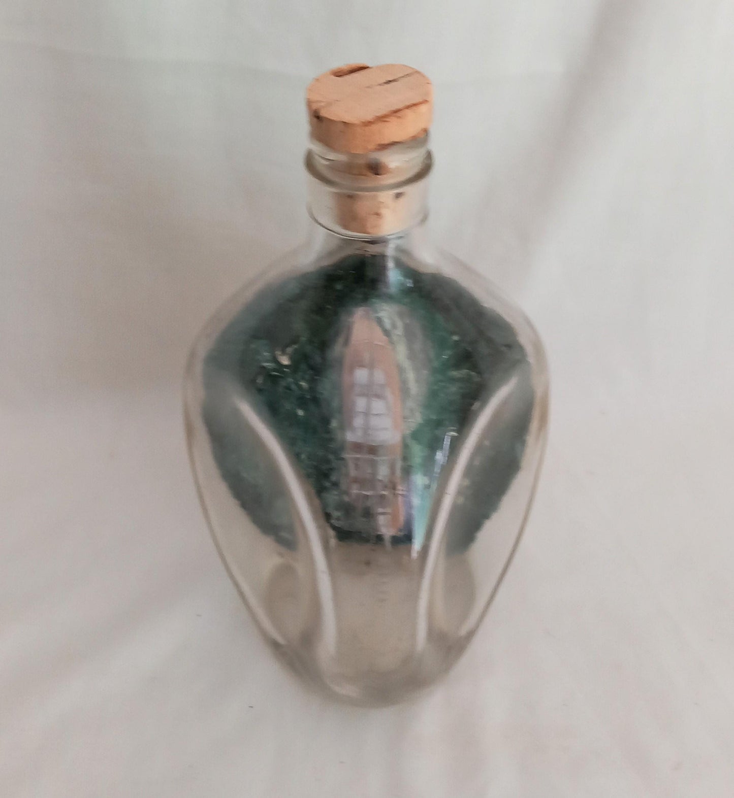 vintage hand made ship in a bottle of HMS Ajax in pinched triangular bottle