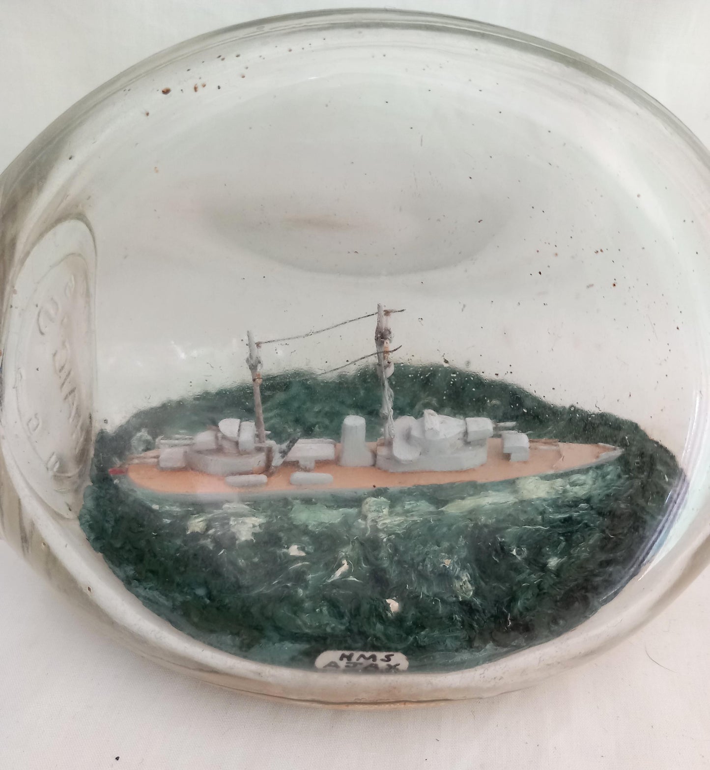 vintage hand made ship in a bottle of HMS Ajax in pinched triangular bottle