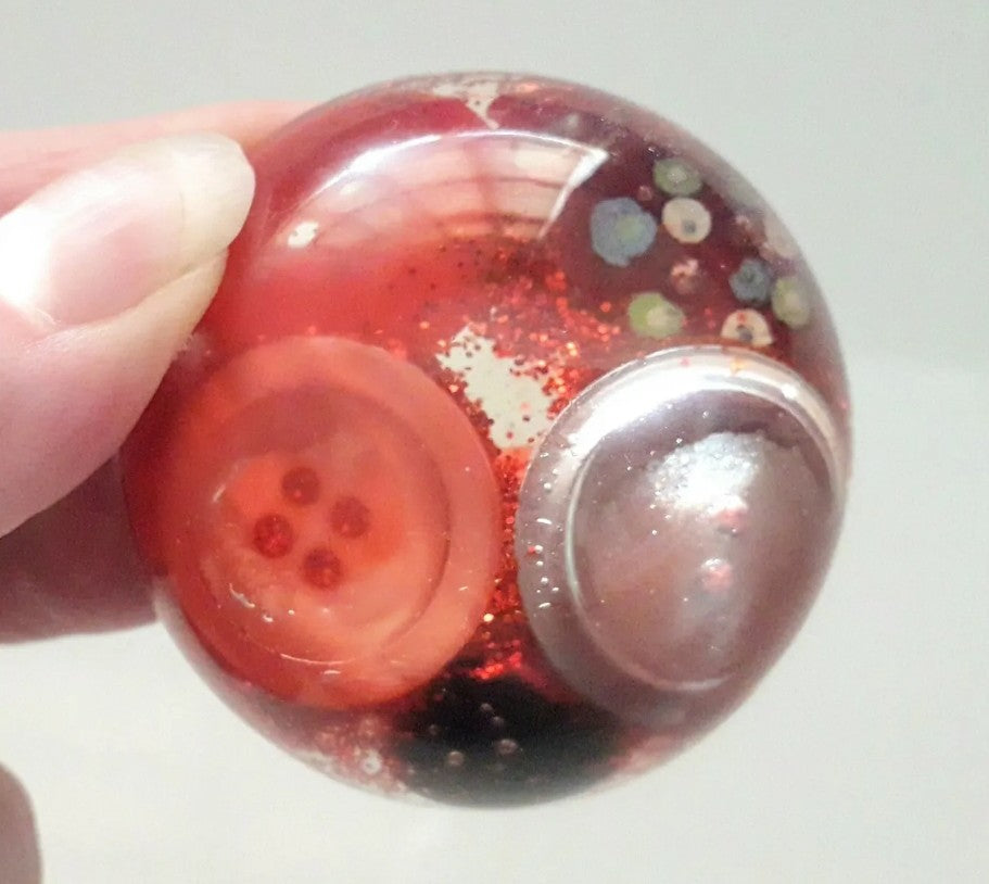 Handmade resin paperweight inlaid with red vintage buttons and glitter