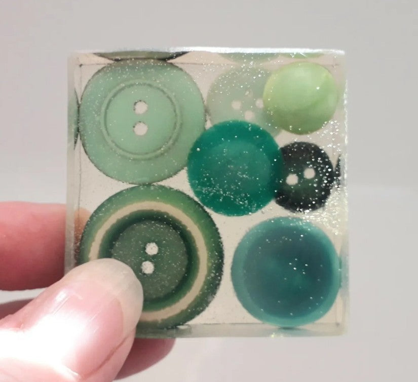 Handmade resin paperweight inlaid with green vintage buttons