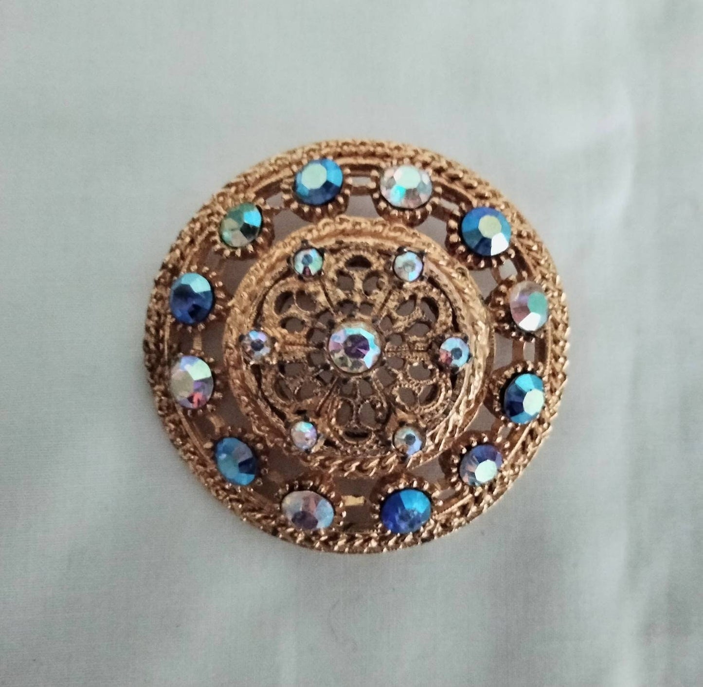1950s goldtone & blue aurora borealis rhinestone large circular brooch