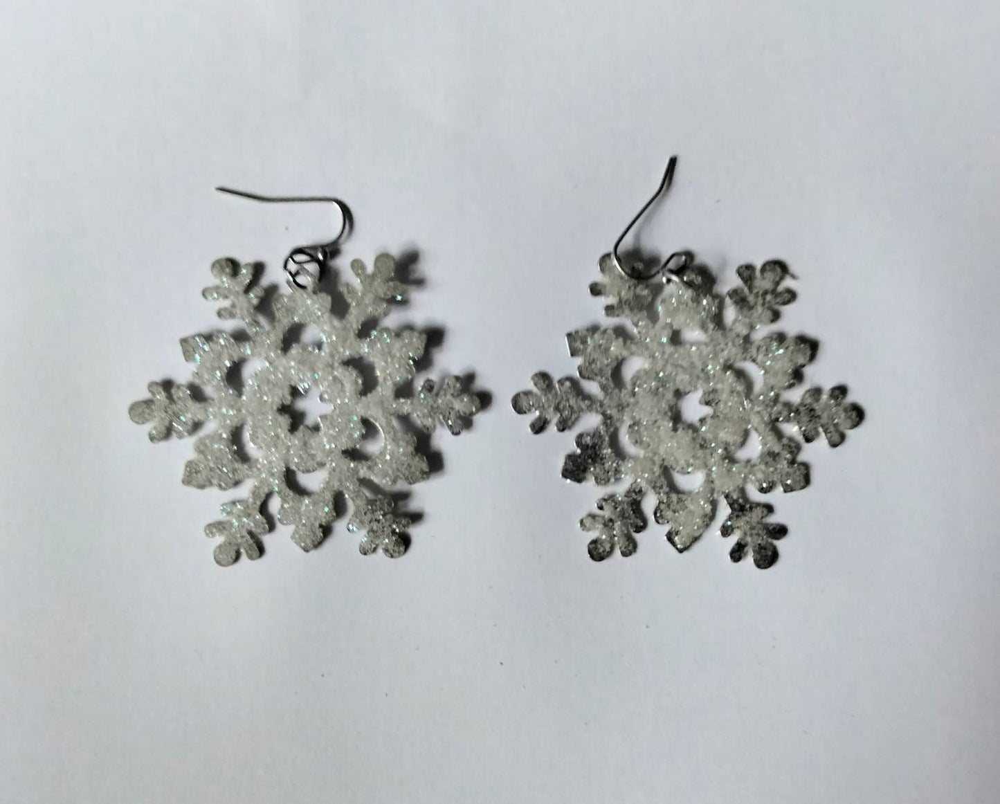 White & blue glitter snowflake dangly winter earrings