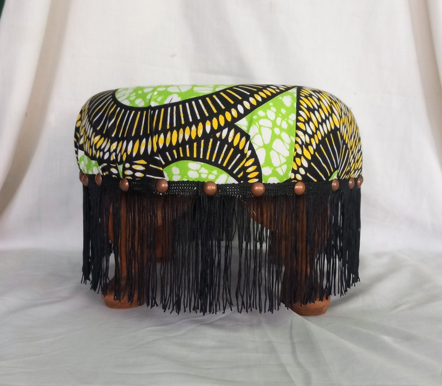 Vintage foot stool reupholstered with green & yellow African tribal print fabric