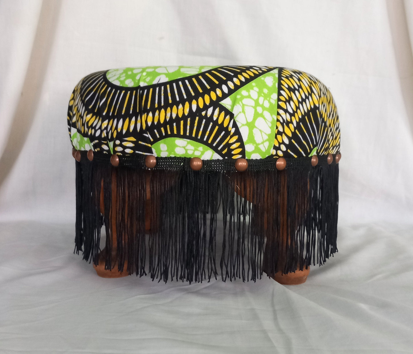 Vintage foot stool reupholstered with green & yellow African tribal print fabric