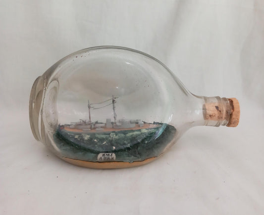 vintage hand made ship in a bottle of HMS Ajax in pinched triangular bottle